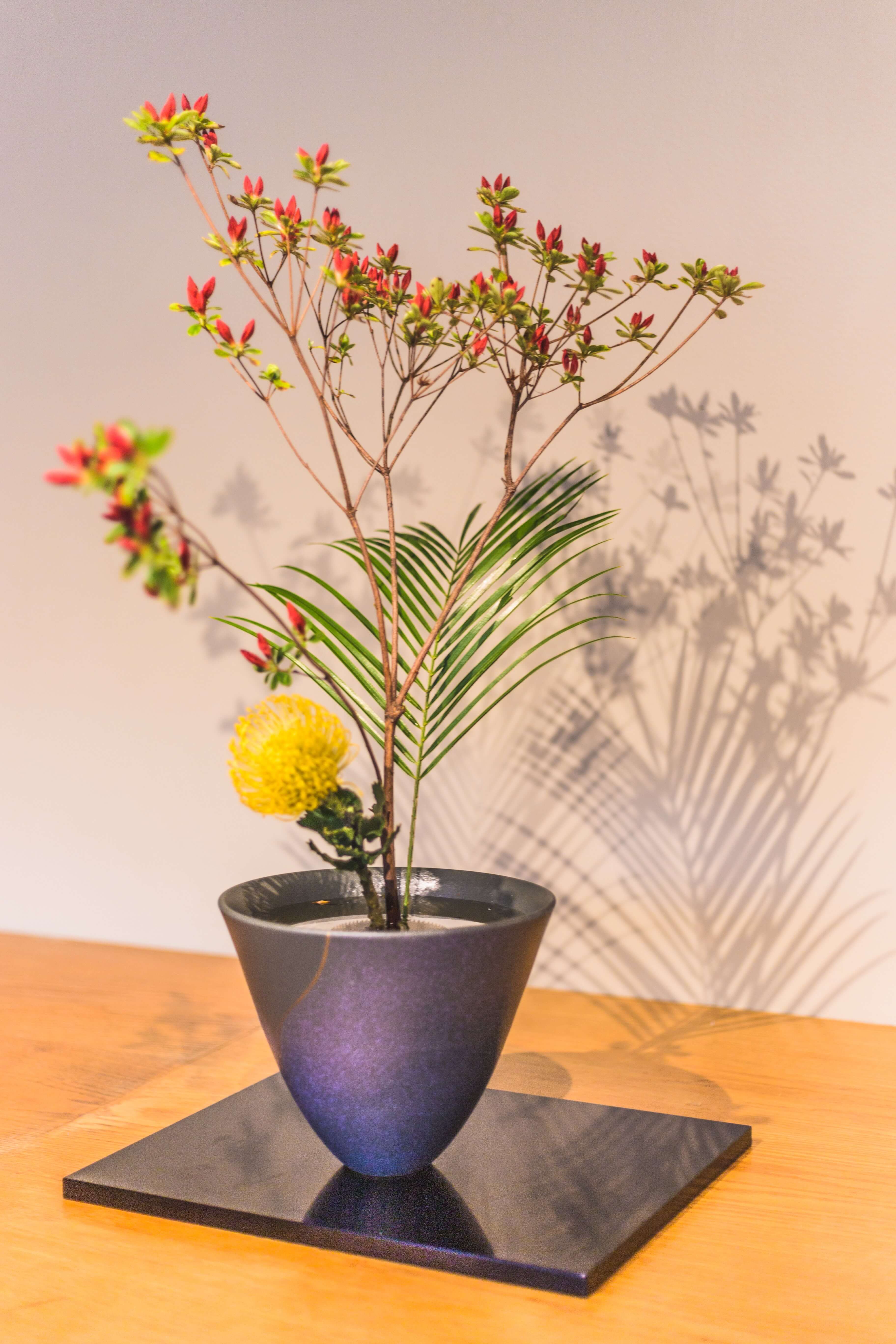 Ikebana - japanische Kunst des Blumenarrangement blaue Vase