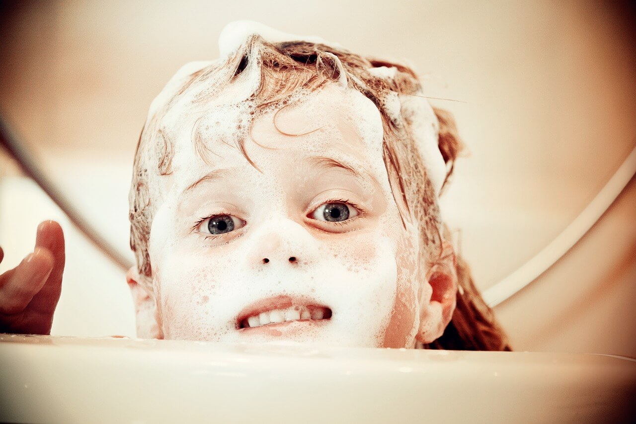 Kind mit Seife im Gesicht