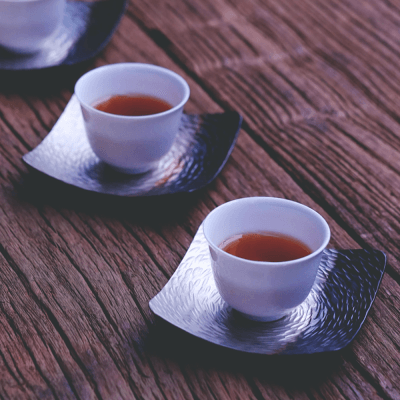 Tee, der durch Porzellanbecher durchscheint